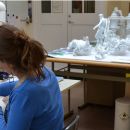 Figure 5. Intern, Roosmarijn van Beemen treating a figurative element depicting a sea-horse. To her right other components of the fountain are grouped to provide an impression of the display. Photography by Hanneke Ramakers © Victoria and Albert Museum, London