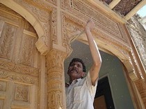 Photograph of a trained craftsman at work restoring a traditional courtyard house. © Shahed Saleem