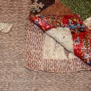 Figure 12 - Patchwork and quilted bedcover, 1810-45, England. Museum no. T.17-1924. Detail of wool flannel and woollen blanket seen through a hole in the lining and where the lining was loose at one corner.