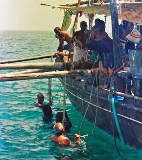 Pearl divers holding onto the rope attached to the collecting baskets, reproduction of original photograph. © Qatar News Agency Archives