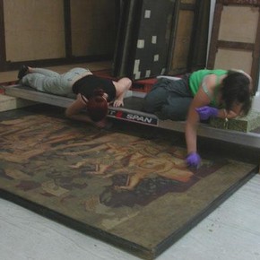 Figure 1. Students using a bridge to clean one of the larger paintings. Photography by Nicola Costaras.