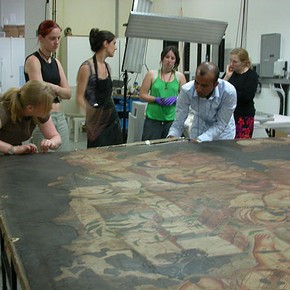 Figure 2. Students strip lining one of the paintings. Photograph by Nicola Costaras.