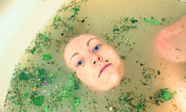 The author partially submerged in water, only her head showing