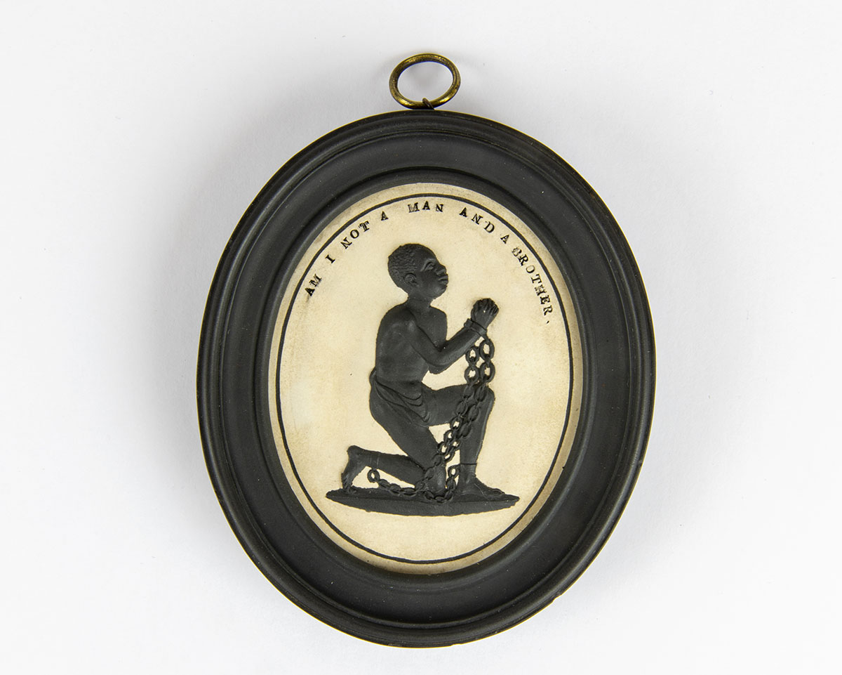 A medallion with a kneeling man in chains