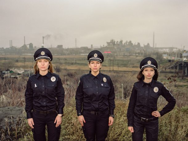 Three women in police uniform look at the camera. 