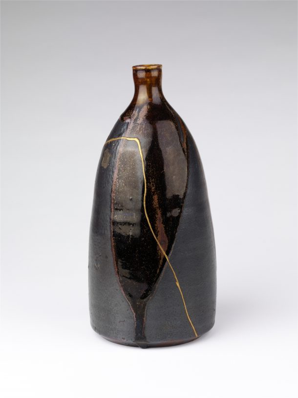 A black bottle with visible gold repairs