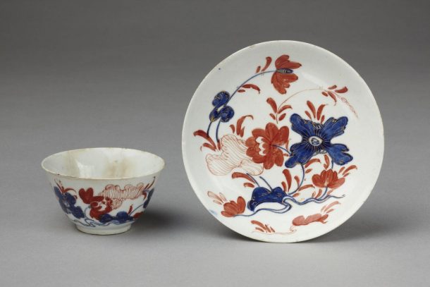 tea cup and saucer decorated with blue and red floral design