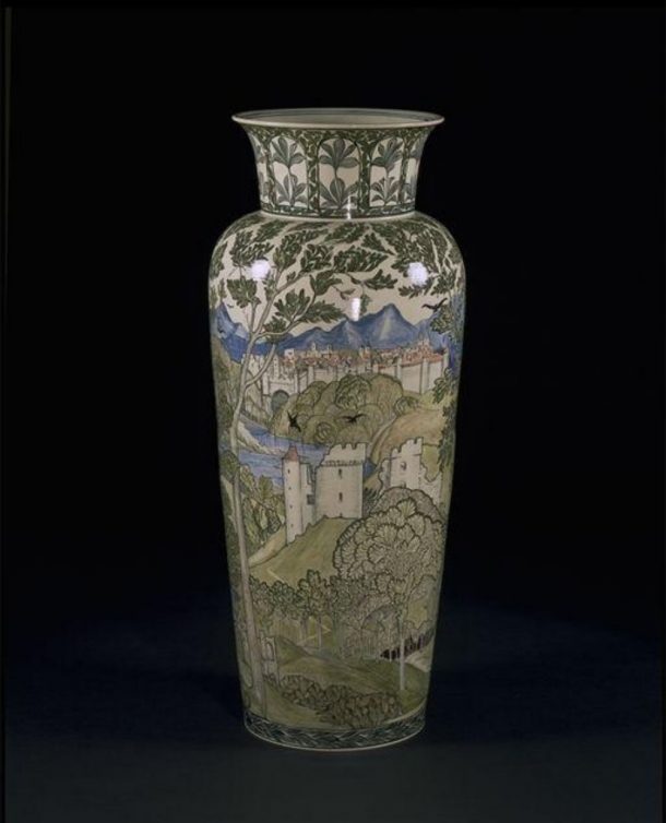 A vase painted with a scene of a castle over rolling hills; a mountain range rises in the background