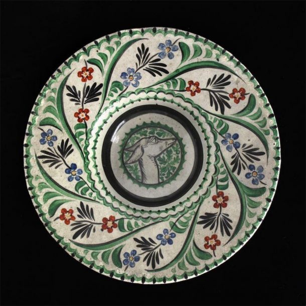 A decorated dish with a dog in the centre