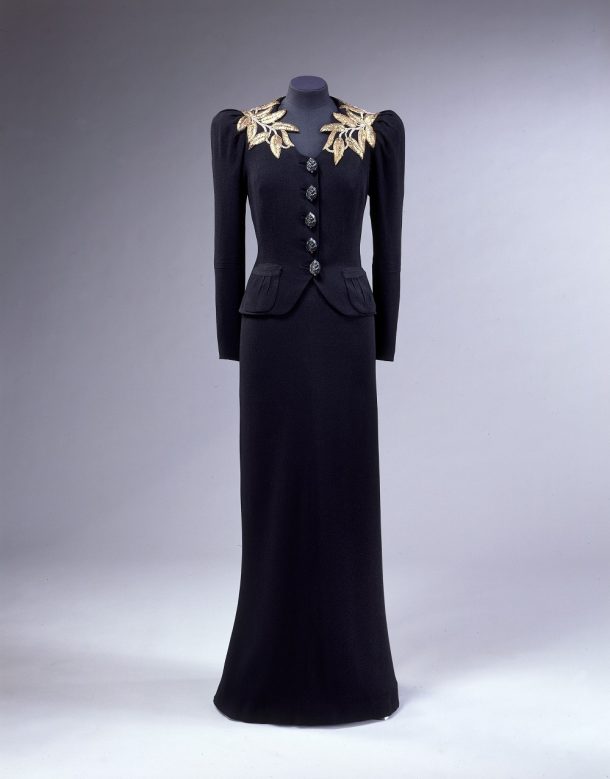 T.399&a-1974 Elsa Schiaparelli, Dress and Jacket with gilt embroidery. Ensemble previously mounted on a torso dress stand.