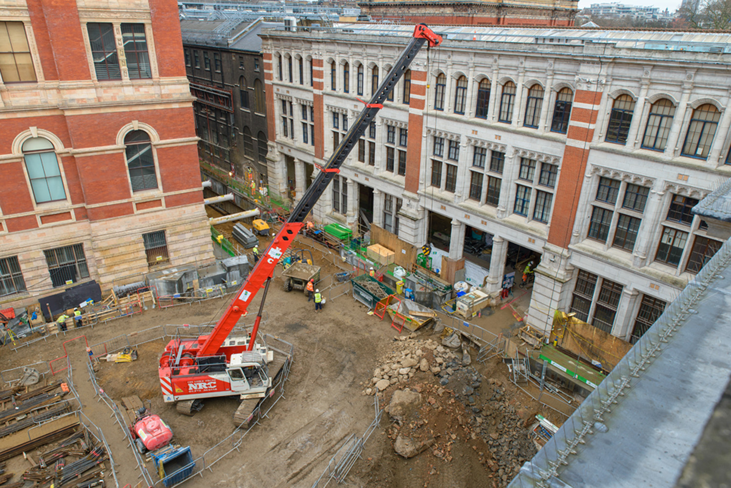    Current construction progress on the Exhibition Road Project site - all disused buildings have been demolished, piling works are complete, and excavation and propping of the site is underway. The three openings in the Western Range (building in the background) will provide a new entrance and lobby for the museum, 2015. © Victoria and Albert Museum, London