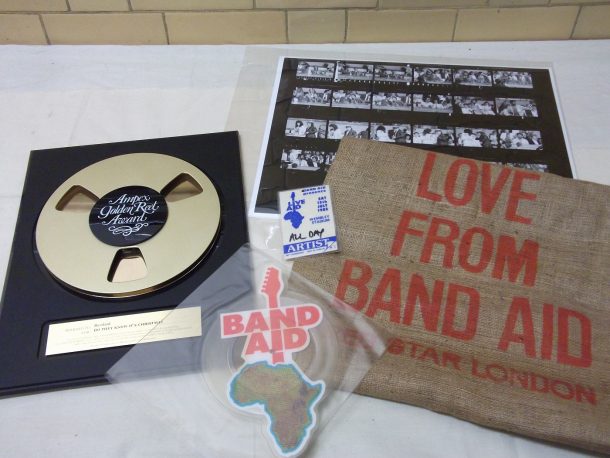 Items from the collection, l-r: gold disc, commemorative lp, contact sheet, AAA pass & grain sack
