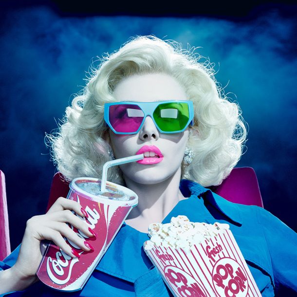 A woman wearing sunglasses seated in a cinema