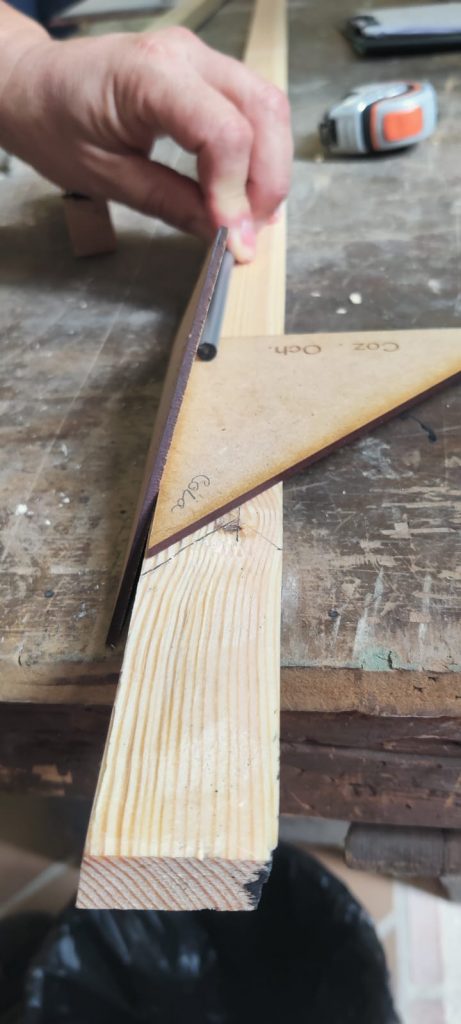 Closeup of a set square resting on a piece of wood