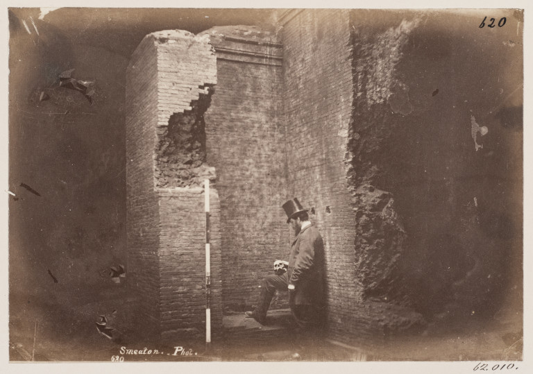 Photograph of a man holding a skull in the Catacomb of S. Domitilla, Rome