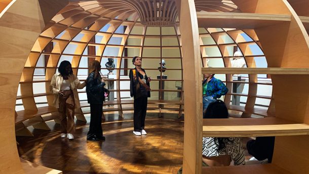 Co-design members looking up, inside a large wooden dome