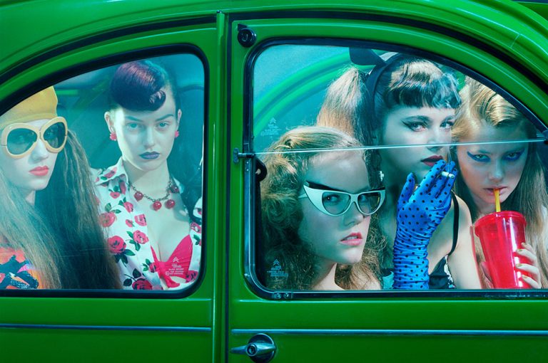 Models looking out of a green car