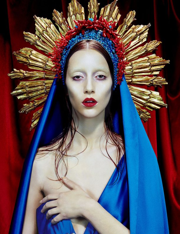 A model dressed as a religious figure wearing a blue dress