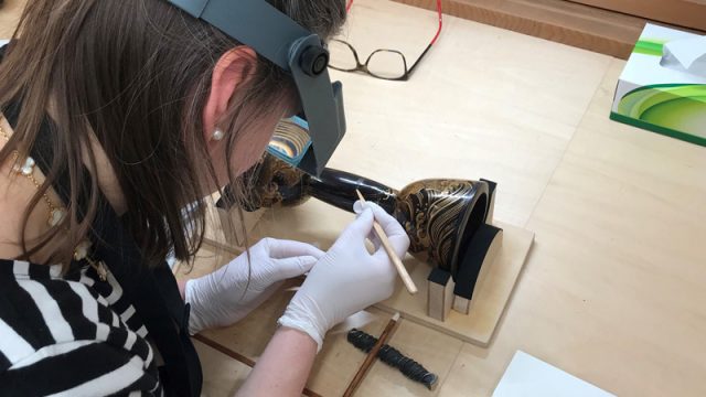 Figure 3. Ms. Melchar using an urushi clay paste to repair damaged foundation layer (Photography by Dana Melchar © Victoria and Albert Museum, London)