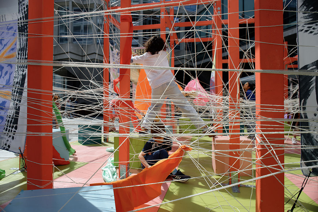 Children having fun climbing in a mesh of string