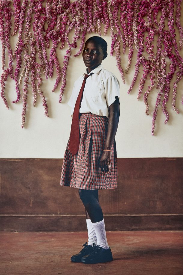 A school pupil in front of a cascade of flowers