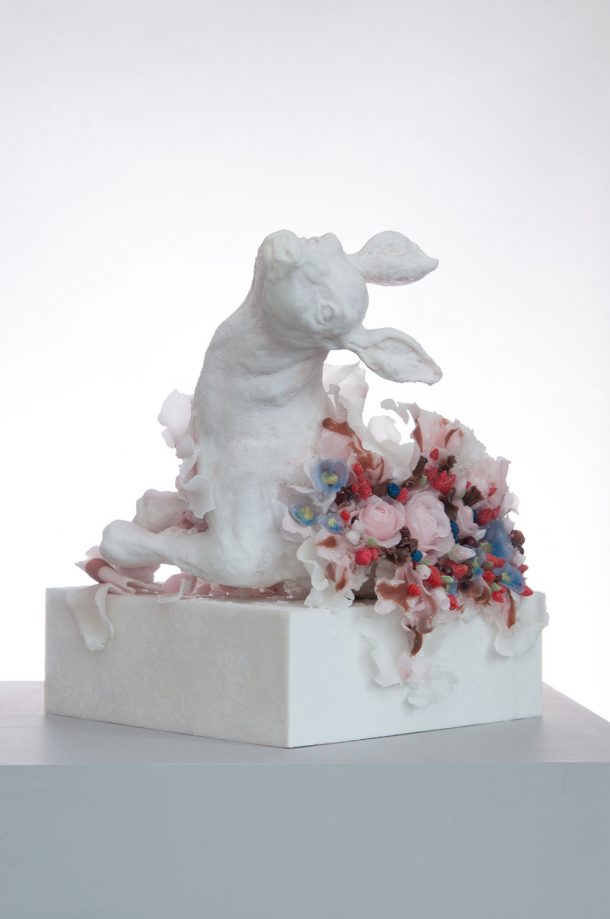 Sculpture of a white rabbit surrounded by flowers