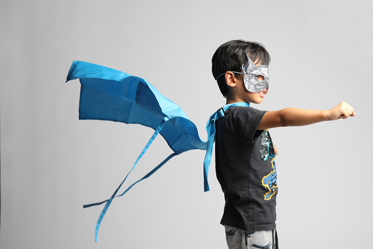 A boy wearing a mask and cape – looking fearless!