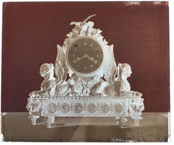 Glass negative of a mantel clock, showing sphinxes