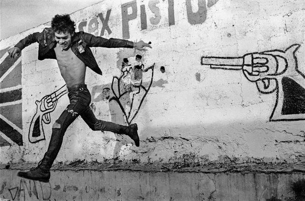 A man jumps in front of graffiti