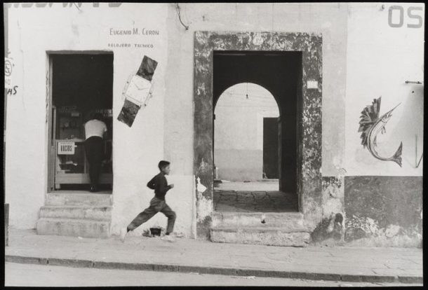 A boy runs downhill past a doorway
