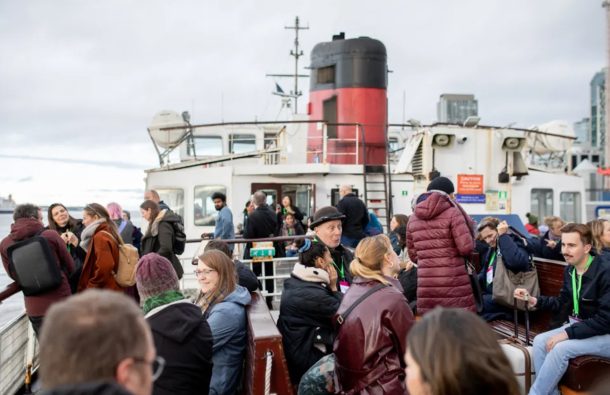 A group of people on a ferry smiling and talking