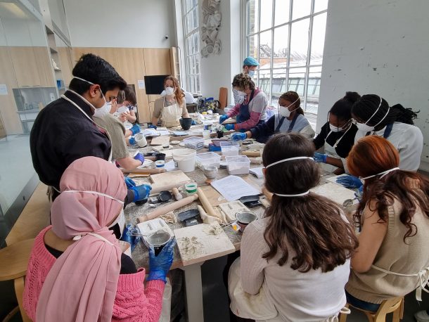 students working with porcelain around a large table