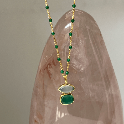 Gold chain necklace with a green onyx pendant.