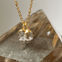 Double crystal and diamond pendant on a gold chain necklace.