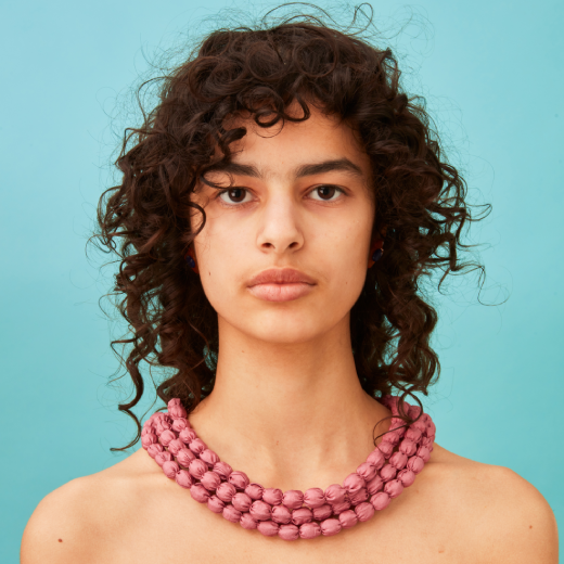 In a simple yet richly textured look our model wears a three-strand necklace under tumbling curls