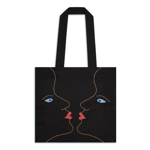 Large size premium tote bag featuring an embroidery of two mirrored, kissing faces that form the illusion of a vase of roses adapted from the Schiaparelli evening coat design