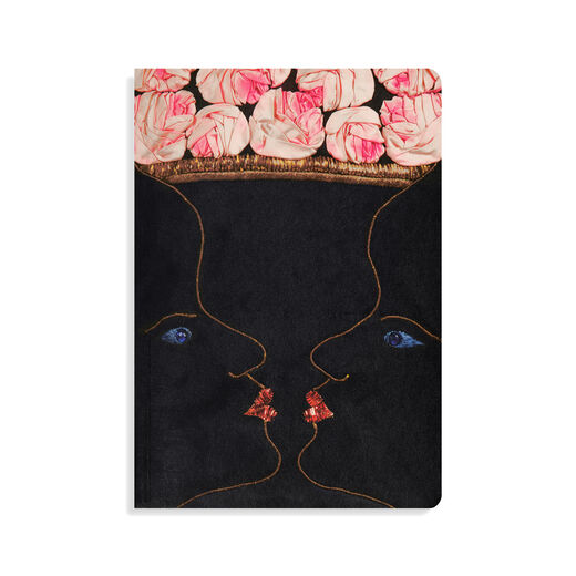 A5 lined journal with front cover featuring two mirrored, kissing faces that form the illusion of a vase of roses adapted from the Schiaparelli evening coat design 
