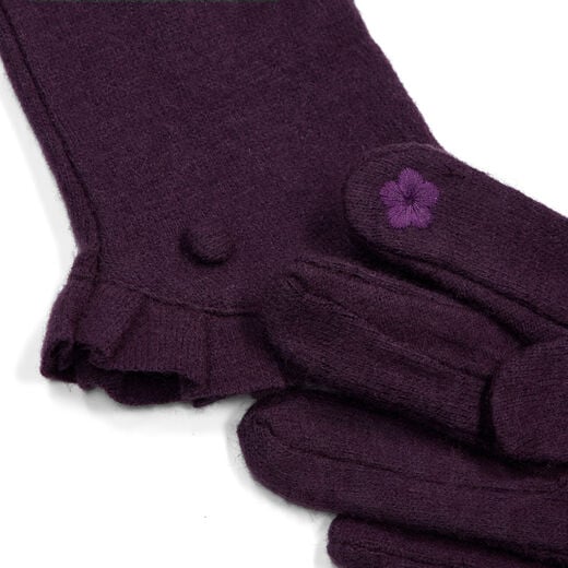 A pair of dark purple gloves featuring a ruffled cuff. The close up shows an embroidered flower on the index fingertip.
