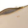 Detail of a beige leather pouch with a gold zip and V&A logo.