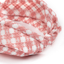 A detail of a fabric headband featuring a white and pink check pattern.