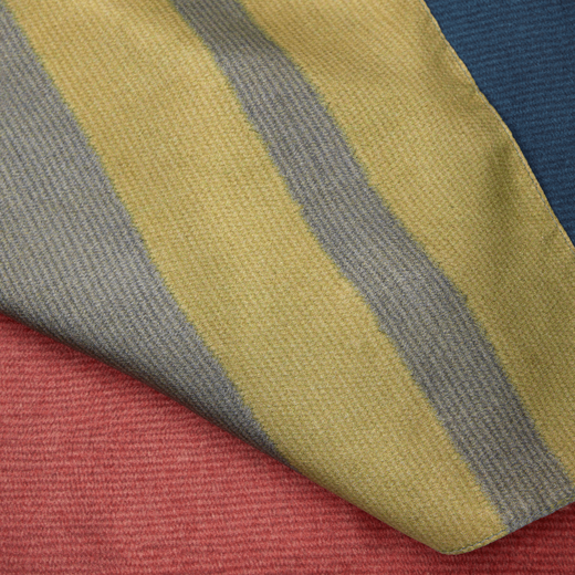 Detail of a yellow, cream and red silk fabric.