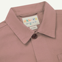 A close up of the nape of a dusty pink Uskees shirt.