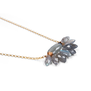 A necklace pendant feturing an array of petal shaped green and grey stones.