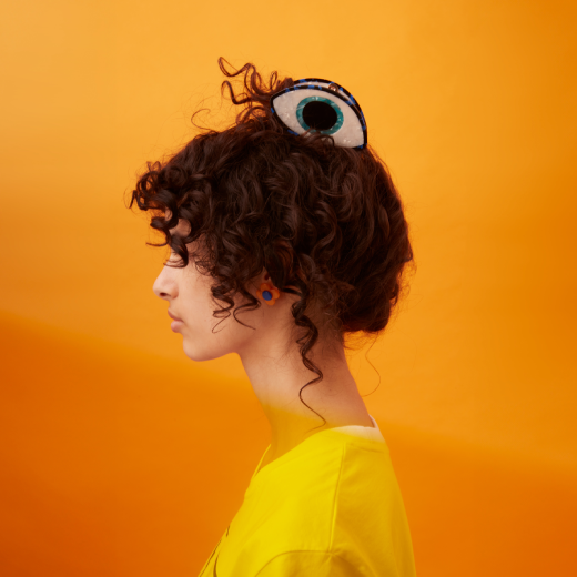 The striking evil eye hair claw commands attention from atop an updo