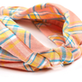 A detail of a fabric headband featuring a pink and orange check pattern.