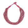 A dusty pink necklace made of three chunky strands of textile beads.