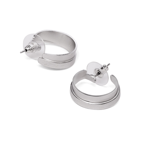A pair f silver hoop earrings lying on a white surface.
