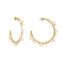 A pair of gold hoop earrings with white pearls.