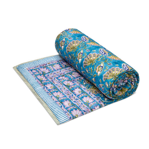 A rolled quilt featuring a floral pattern in pink, purple and blue shades.