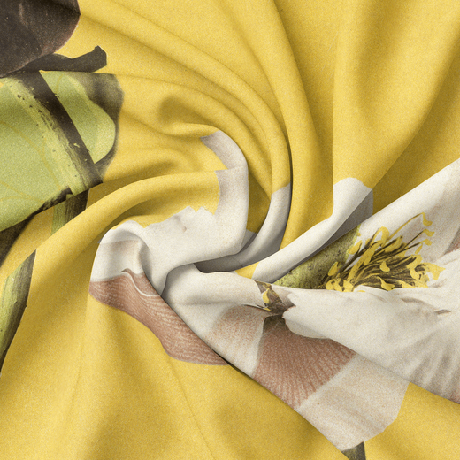 A detail of a scarf featuring a lotus flower on a yellow background, wrapped up in the middle. 